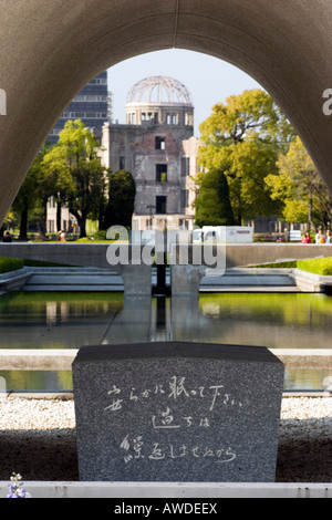 I fiori sono posizionati nella parte anteriore del cenotafio costruito per ricordare le migliaia di vittime uccise con la prima bomba atomica Foto Stock