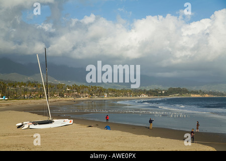 CALIFORNIA Santa Barbara gente camminare lungo il bordo delle acque sulla spiaggia a est delle Montagne e l'Oceano Pacifico mare gabbiani in acqua poco profonda Foto Stock