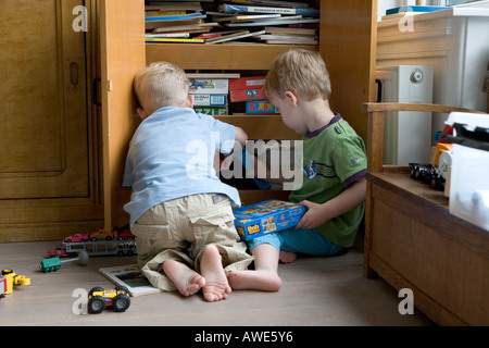 Due ragazzi nella parte anteriore di un armadio giocattolo Foto Stock