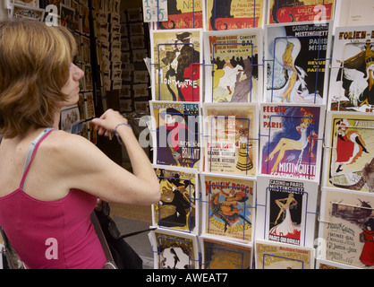 Turista acquisto presso il negozio di strada a Montmartre Parigi manifesti da o in stile di Toulouse Lautrec Foto Stock