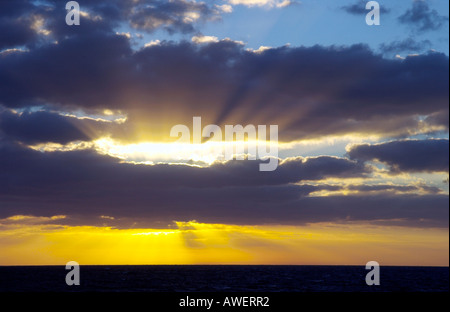 Tramonto con sunburst e nuvole sopra l'Oceano Atlantico da una nave da crociera. Foto Stock