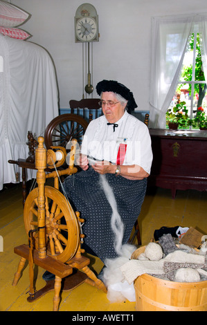 Una dimostrazione di filatura della lana con una ruota di filatura al Mennoniate Heritage Village in Steinbach di Manitoba in Canada Foto Stock