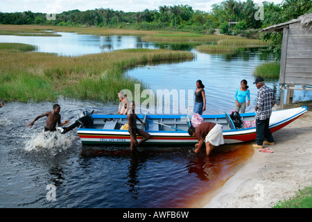 Barca con persone presso la banca del lago Capoey, Guyana, Sud America Foto Stock