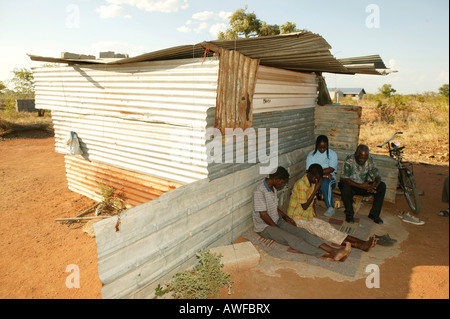 HIV/AIDS infettati coppia di fronte a loro di metallo ondulato capanna di essere visitato da un pastore, Francistown, Botswana, Africa Foto Stock