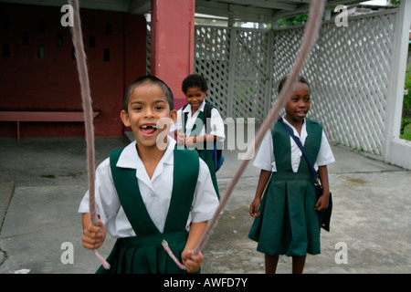 Ragazze vestiti in uniformi di scuola giocando con una corda da salto in un convento delle Orsoline e orfanotrofio in Georgetown, Guyana, Sud Foto Stock