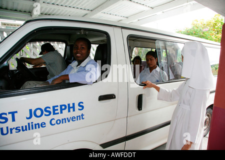 Scuola bus di prelevare i bambini, la vita quotidiana in un convento delle Orsoline e orfanotrofio in Georgetown, Guyana, Sud America Foto Stock