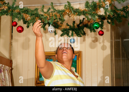 Donna decorare il suo appartamento per Natale, Georgetown, Guyana, Sud America Foto Stock