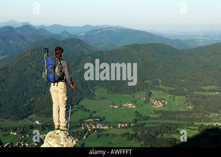 Uomo in piedi su una roccia guardando verso il fondo valle, Breitenstein Mountain, prealpi bavaresi, Wendelstein Gruppo, Alta Baviera, Ba Foto Stock