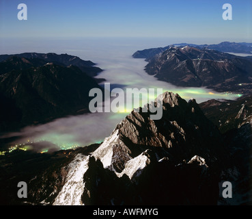 Luci incandescente in un mare di nebbia attorno a Mt. Waxenstein, visto da Mt. Zugspitze, gamma di Wetterstein, Alta Baviera, Baviera, Ger Foto Stock
