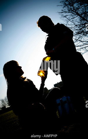 Adolescente di bere una bottiglia di alcool in un parco funzionario di polizia sequestro potabile minorenni Foto Stock