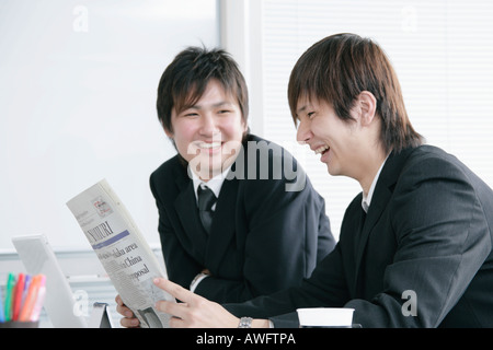 Due giovani imprenditori quotidiano di lettura Foto Stock