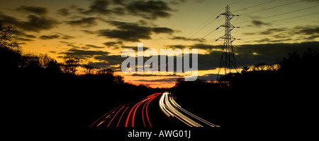 I percorsi del traffico sulla A3 a doppia carreggiata vicino a Guildford al tramonto Surrey in Inghilterra REGNO UNITO Foto Stock