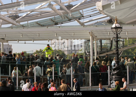 La folla di turisti attendere in linea coda per un giro sulla famosa attrazione Landmark London Eye UK Gran Bretagna Europa Foto Stock