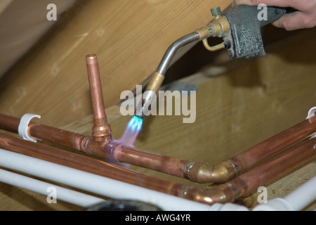 Un idraulico la saldatura di tubi in una nuova casa Foto Stock