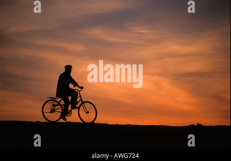 Uomo in bicicletta al tramonto Phnom Khrom Tonle Sap Cambogia Foto Stock