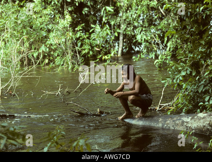 Amerindian boy pesci per piranha con linea fiume Mazaruni Guyana Foto Stock