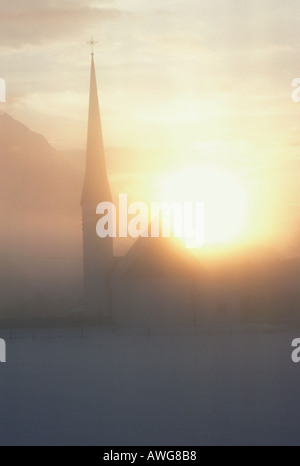 Europa Germania Baviera Oberammergau tramonto su una montagna di foggie in scena con la chiesa in inverno Foto Stock