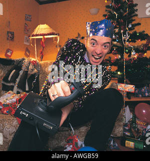 Un uomo si gioca su una console di gioco al tempo di Natale Foto Stock