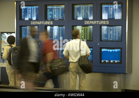 I viaggiatori si affrettò a passare le pianificazioni della compagnia aerea a Detroit, Michigan. Foto Stock