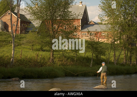 Un pescatore a mosca getta la sua linea su Mad River in Waisfield, Vermont in una impostazione paese. Foto Stock