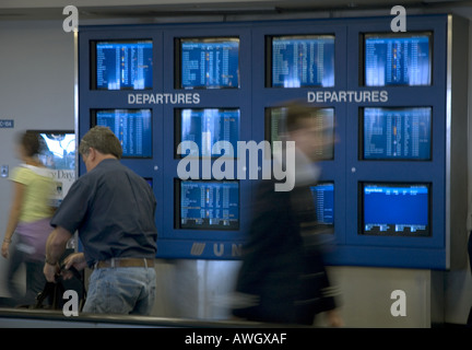 I viaggiatori si affrettò a passare le pianificazioni della compagnia aerea a Detroit, Michigan. Foto Stock