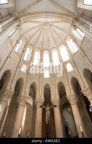 L'interno del monastero di Alcobaca in Portogallo che mostra le pareti finestre a soffitto e il crocifisso sopra l'alter. Foto Stock