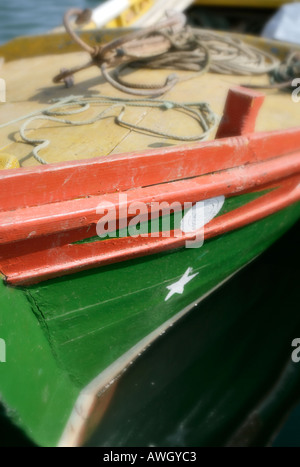 Un dipinto luminosamente colorata barca da pesca vicino alla spiaggia di Alvor sul Portogallo s costa Algarve Foto Stock