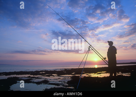 Silhouette del pescatore sulla spiaggia al tramonto West Aberthaw Vale of Glamorgan Galles del Sud Foto Stock