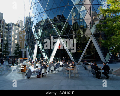 Imprenditori lavoratori ufficio avente il pranzo Pranzo alla base della Svizzera edificio di riassicurazione a k a il Gherkin London REGNO UNITO Foto Stock