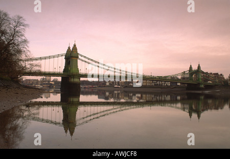 Vista della sospensione di Hammersmith Bridge nella zona ovest di Londra si riflette nel fiume Tamigi, England, Regno Unito Foto Stock
