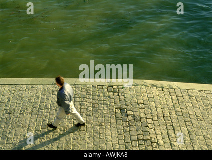 Francia, Parigi, uomo a camminare lungo la banchina del fiume Senna Foto Stock