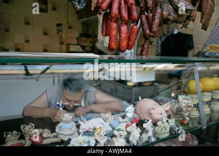 Una donna svolge una croce parola puzzle in attesa per i clienti Foto Stock