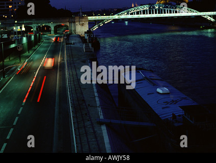 Francia, Parigi, vetture che viaggiano sul quai di notte, sfocata. Foto Stock