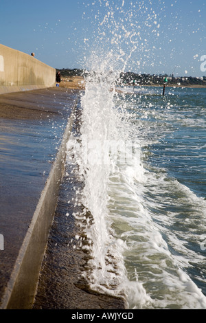 Un'onda rotoli sul mare difese a Avon Spiaggia Christchurch durante la marea massima dell'anno Foto Stock