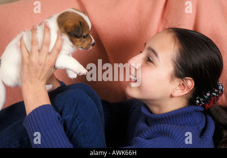 Ragazza adolescente giocando con jack russell cucciolo Foto Stock