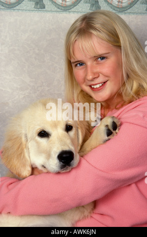 Ritratto bionda ragazza adolescente con il golden retriever cucciolo Foto Stock