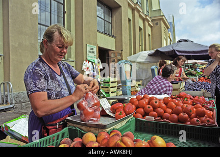 La donna la vendita di frutta e verdura al mercato centrale di Riga, Lettonia Foto Stock