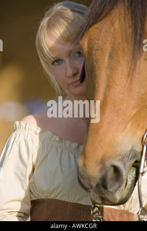 Donna bionda con il proprio cavallo marrone Foto Stock