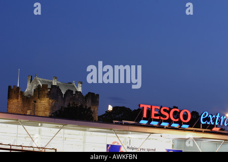 Tesco Extra al crepuscolo con riflettori, storico Alloa Tower si ergono al di sopra e dietro il negozio. Foto Stock