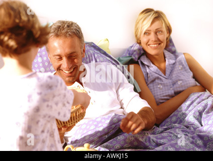 Un giovane bambino portando cestello per i genitori in letto. Foto Stock