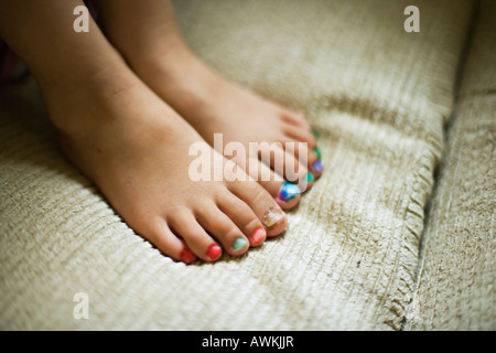 Bambina di età compresa tra i quattro anni di vernici a mano la propria toenails con punta in feltro penne Foto Stock