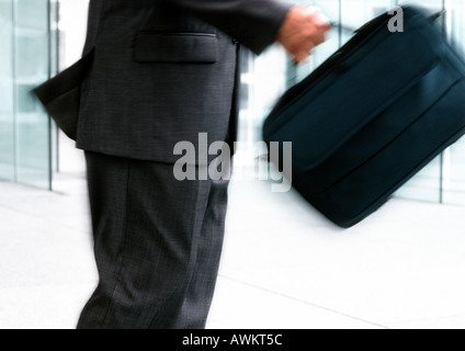 Uomo che porta la borsa per notebook, metà sezione, movimento sfocato Foto Stock