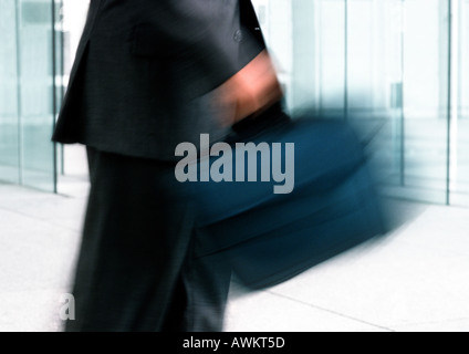 Uomo che porta la borsa per notebook, metà sezione, movimento sfocato Foto Stock