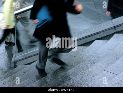 L'uomo salendo le scale, bassa sezione, movimento sfocato Foto Stock