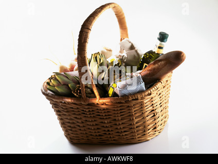 Cestello di mercato contenente pane, carciofi e bottiglia Foto Stock