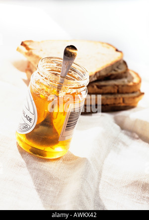 Fette di pane tostato e un vasetto di marmellata di arance Foto Stock