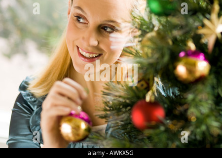 Donna decorare l'albero di Natale Foto Stock