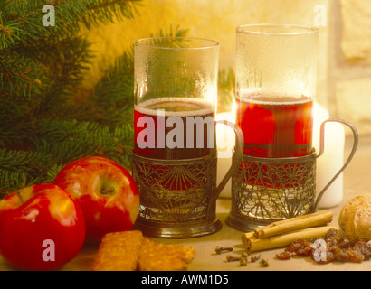 Close-up di tazze di tè con le mele rosse vicino a un albero di Natale Foto Stock