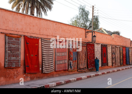 Colorati tappeti berberi drappeggiato lungo una parete lunga nello storico quartiere della Medina, Marrakech, Marocco, Africa Foto Stock