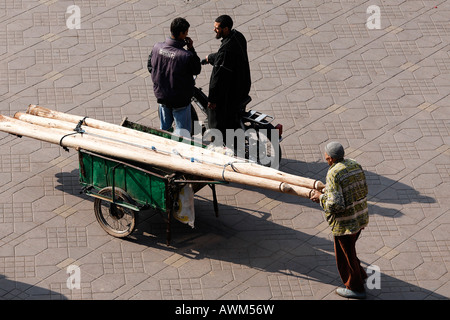 L'uomo spingendo il carrello caricato con travi in legno, Djemaa el Fna a Marrakech, Marocco, Africa Foto Stock